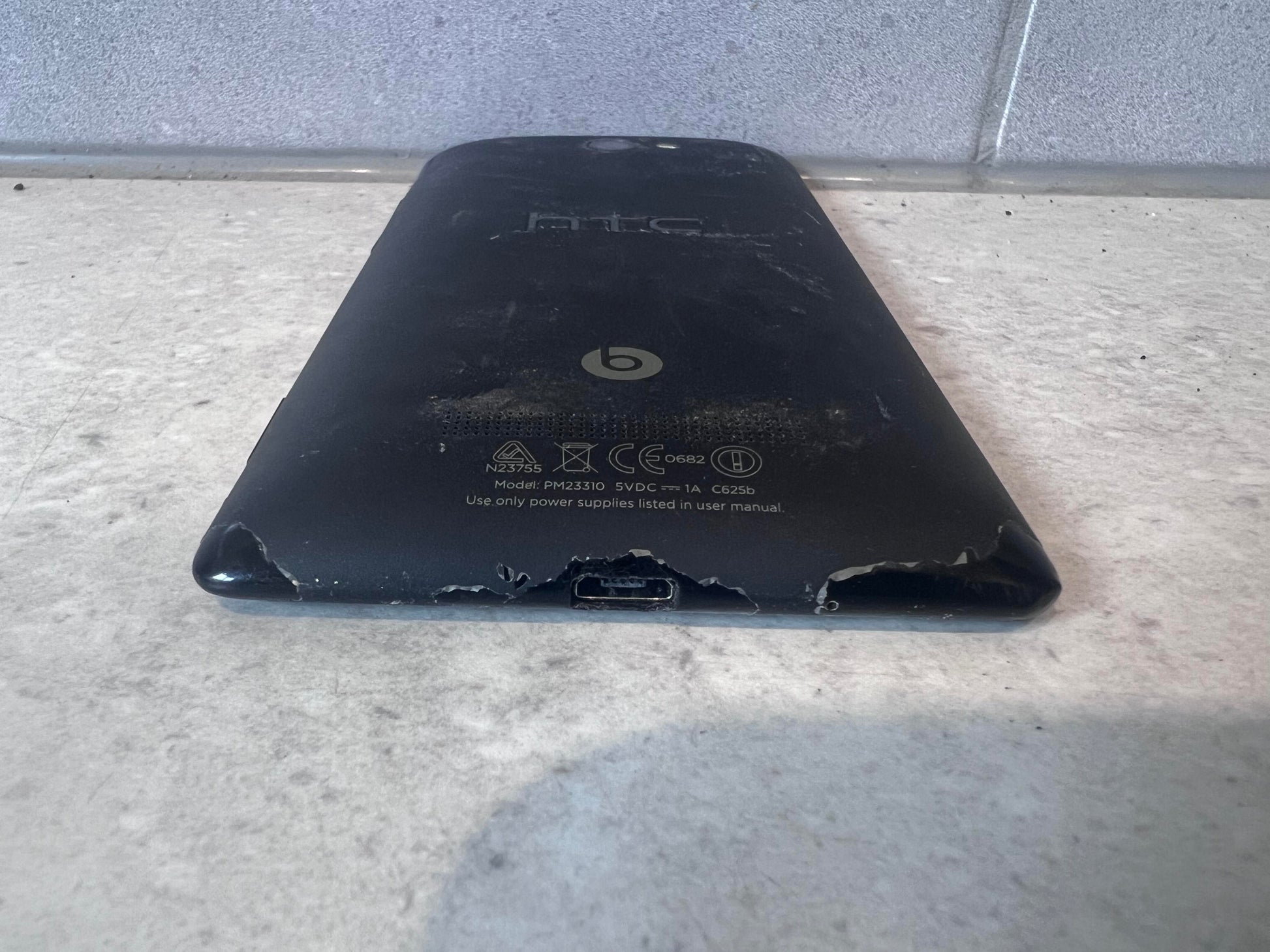 Bottom angle of HTC smartphone showing wear and charger port