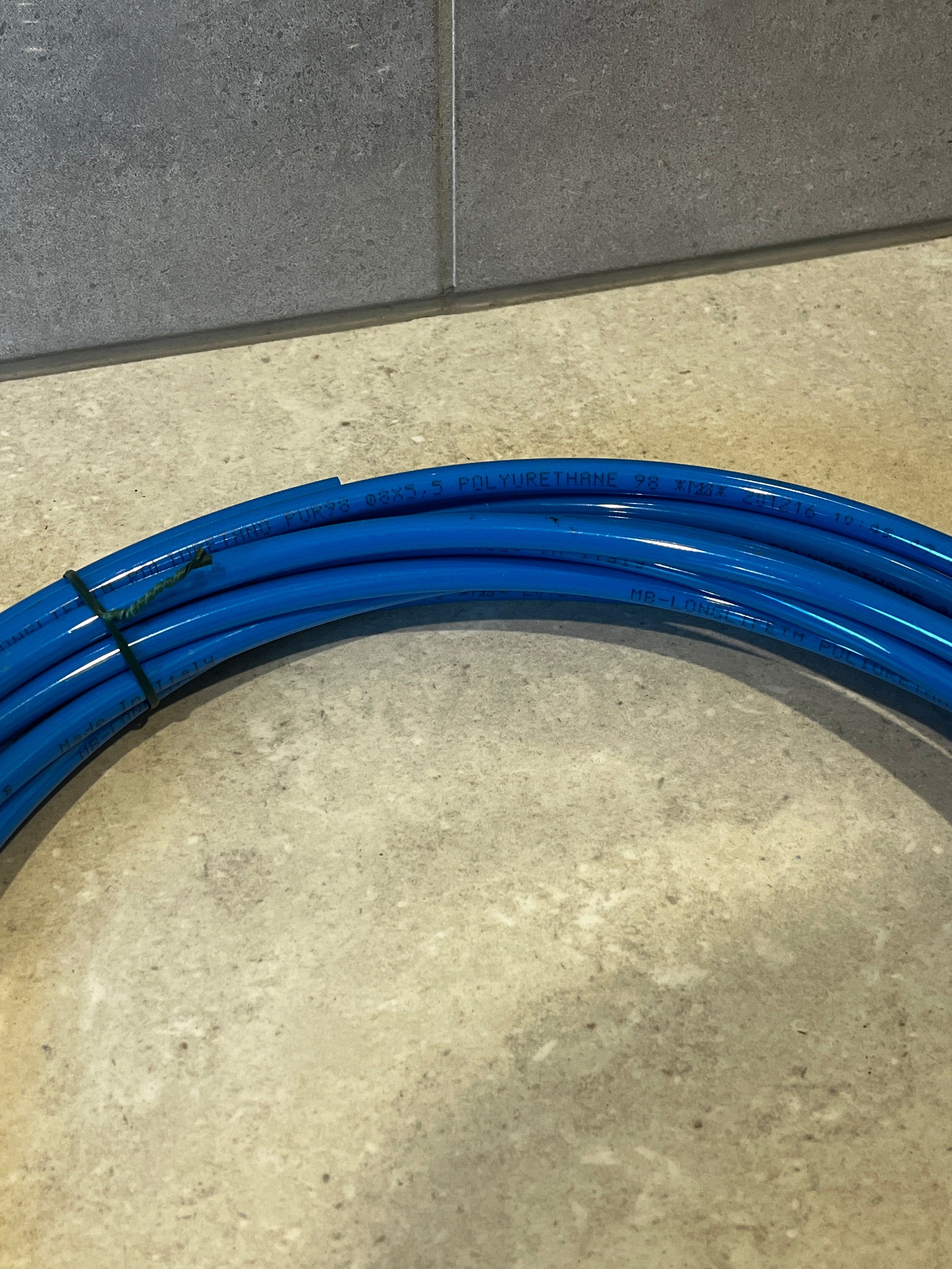 Detailed view of blue polyurethane tubing coil with printed technical details