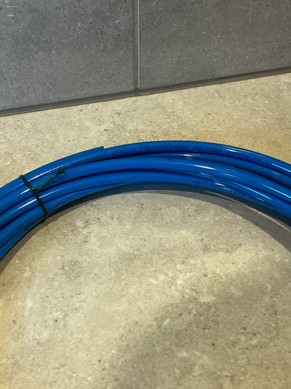 Detailed view of blue polyurethane tubing coil with printed technical details