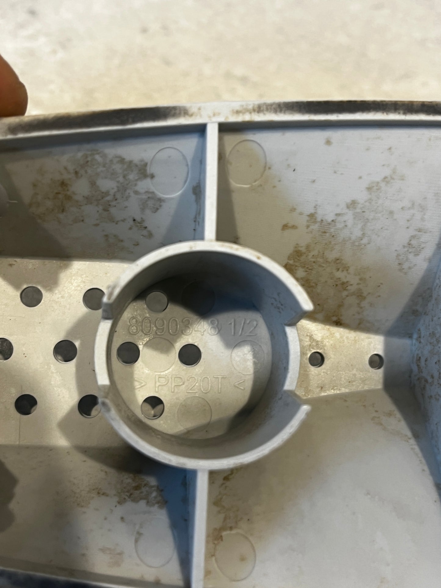 Close-up of interior stamp and structural details of a dishwasher rack roller assembly
