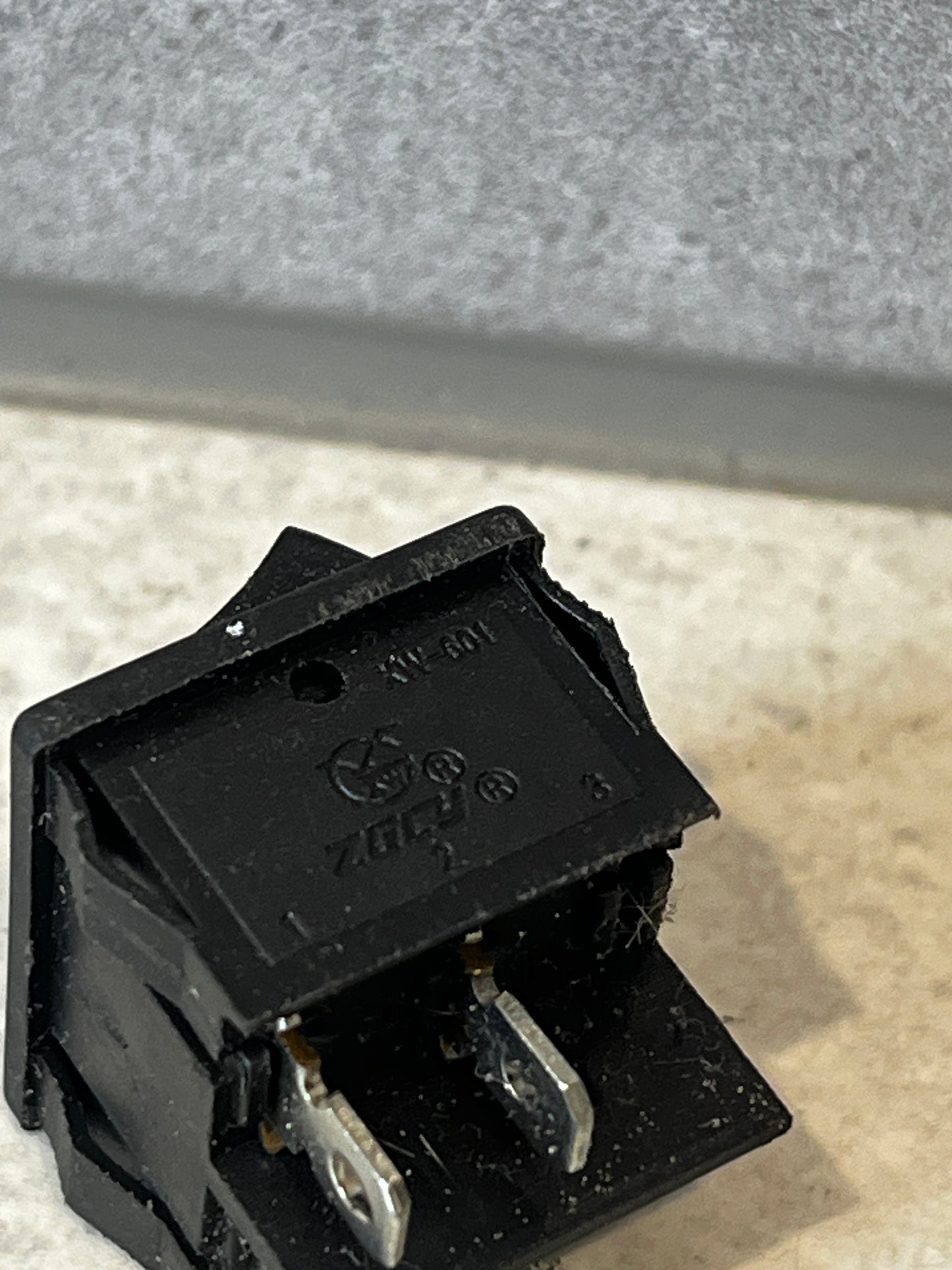 Close-up of the back terminals and housing of the black rocker switch