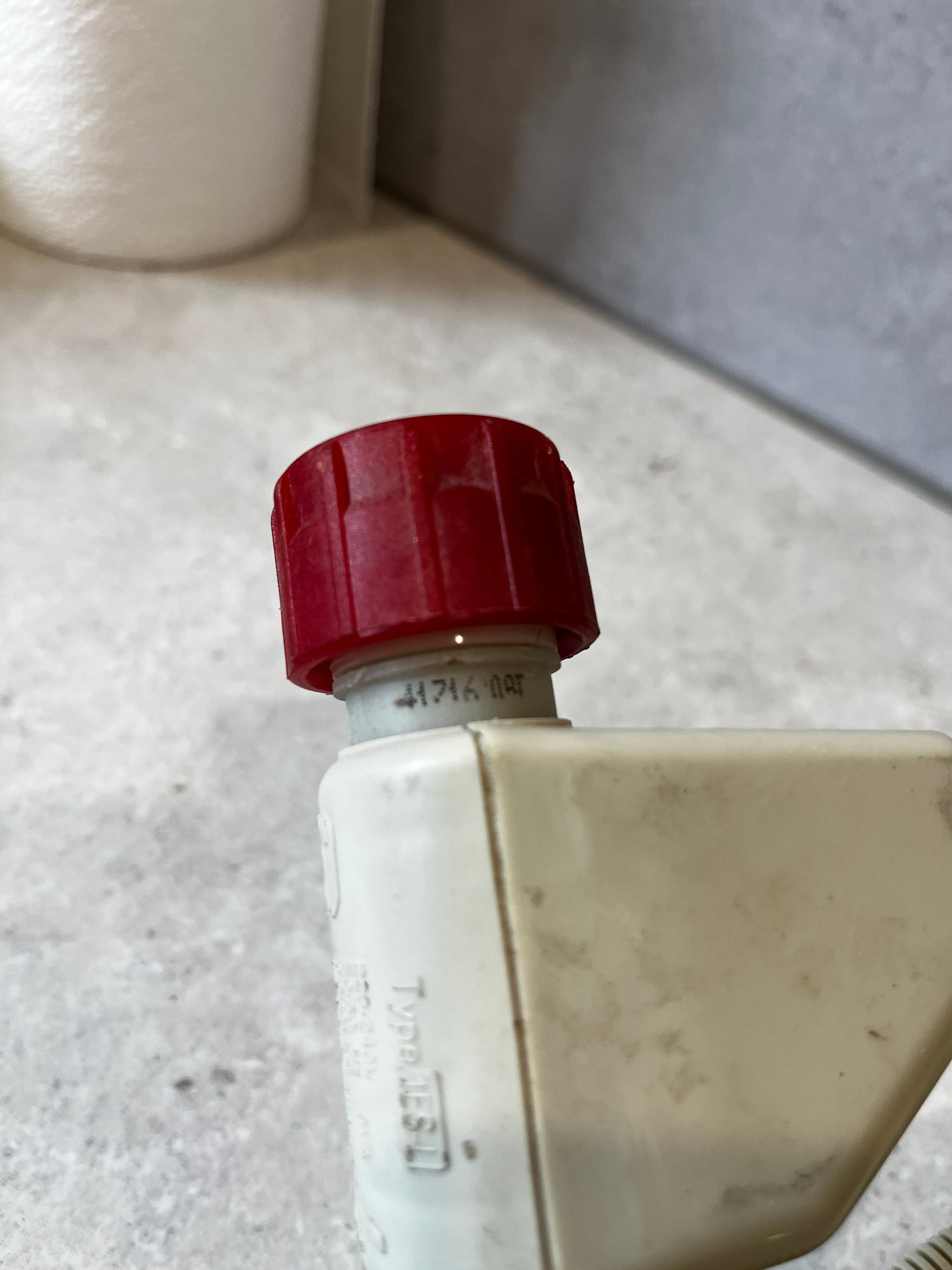 Red cap connector detail on washing machine inlet hose valve