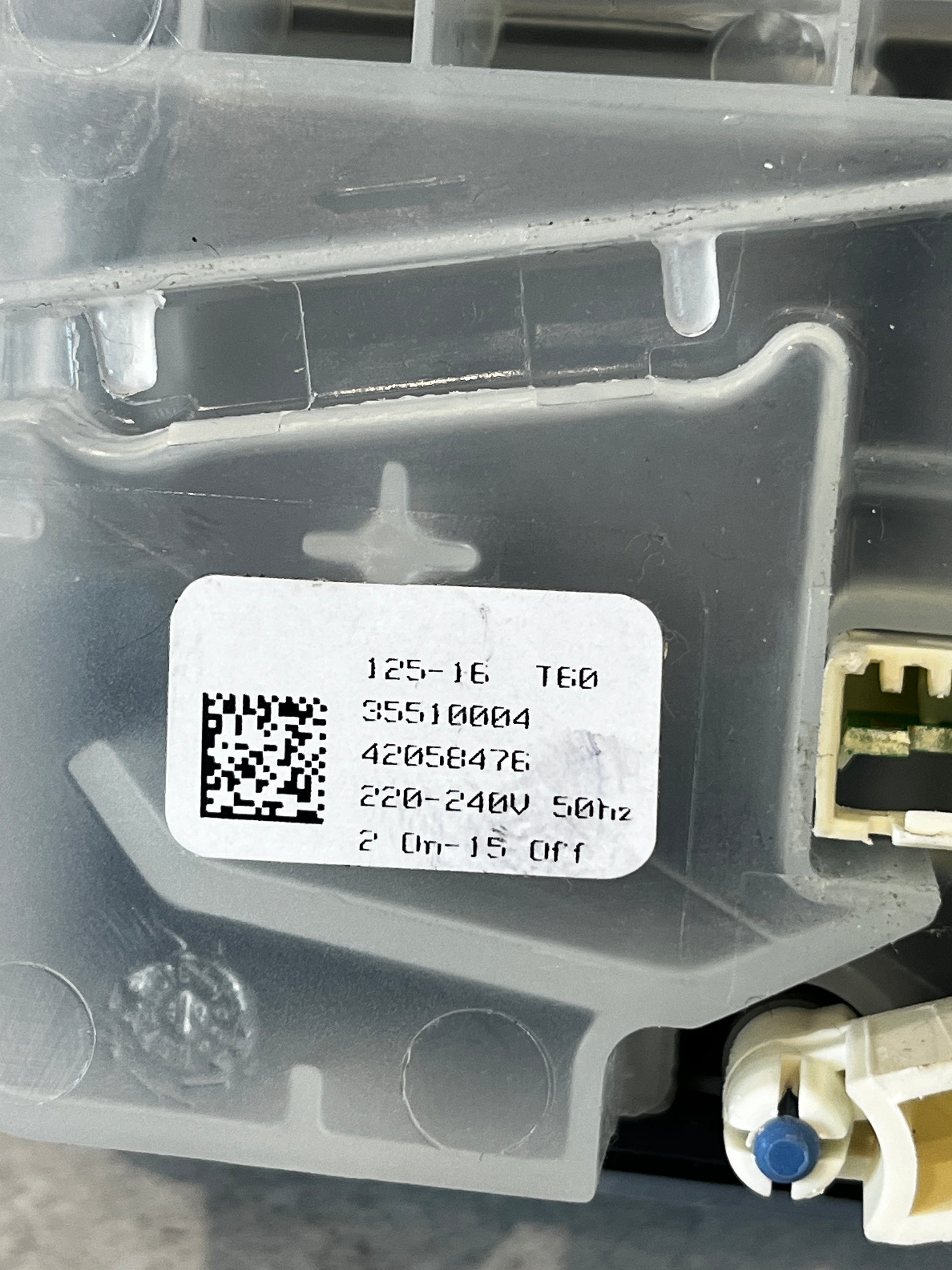 Close-up of label on dishwasher detergent dispenser assembly with voltage details