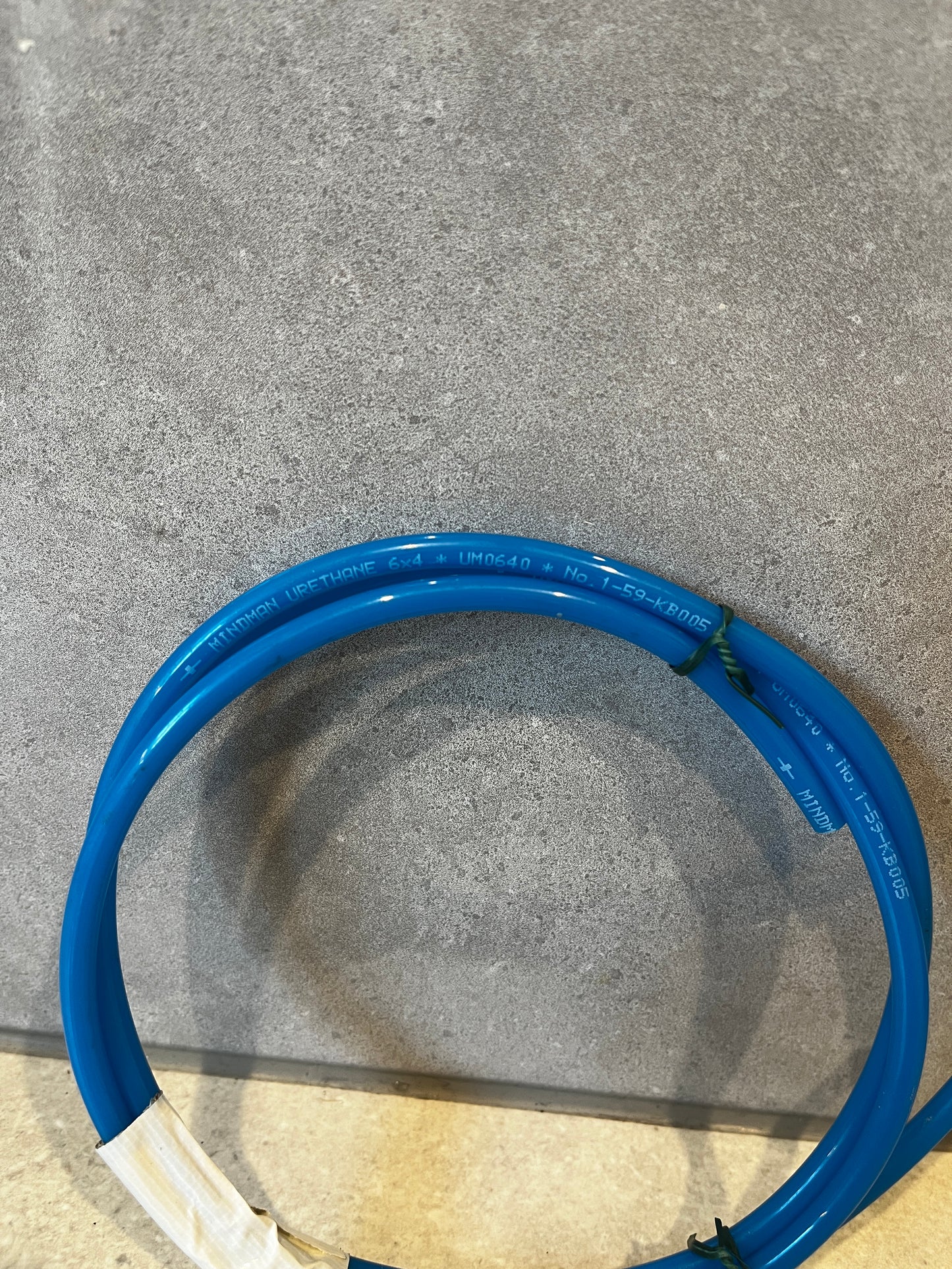 Close-up of blue urethane tubing showing material and printed markings
