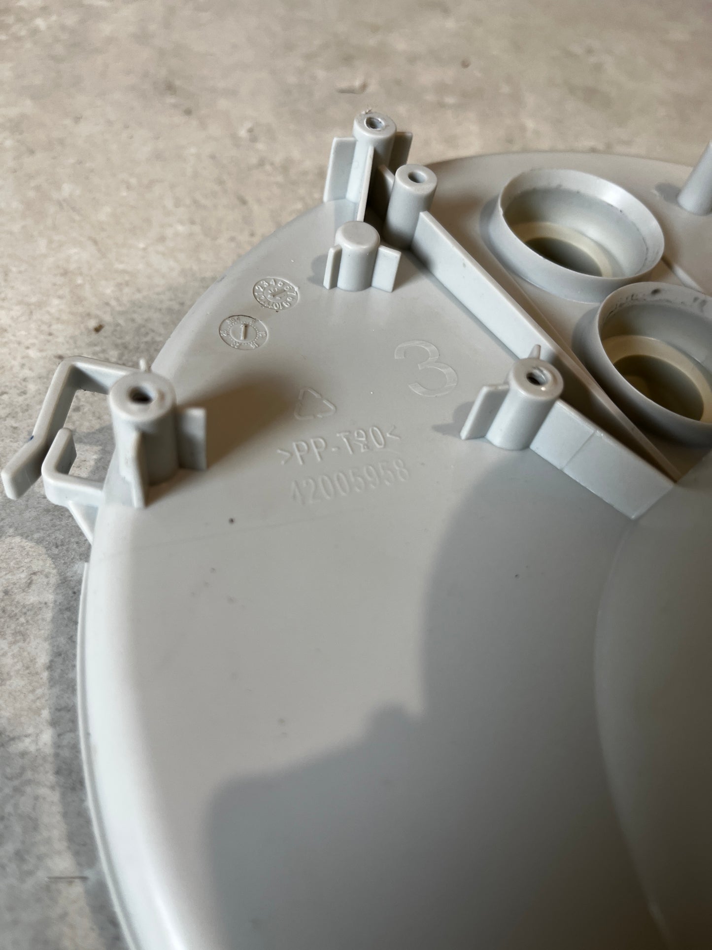 Close-up of mounting points, markings, and material info on the pump filter housing