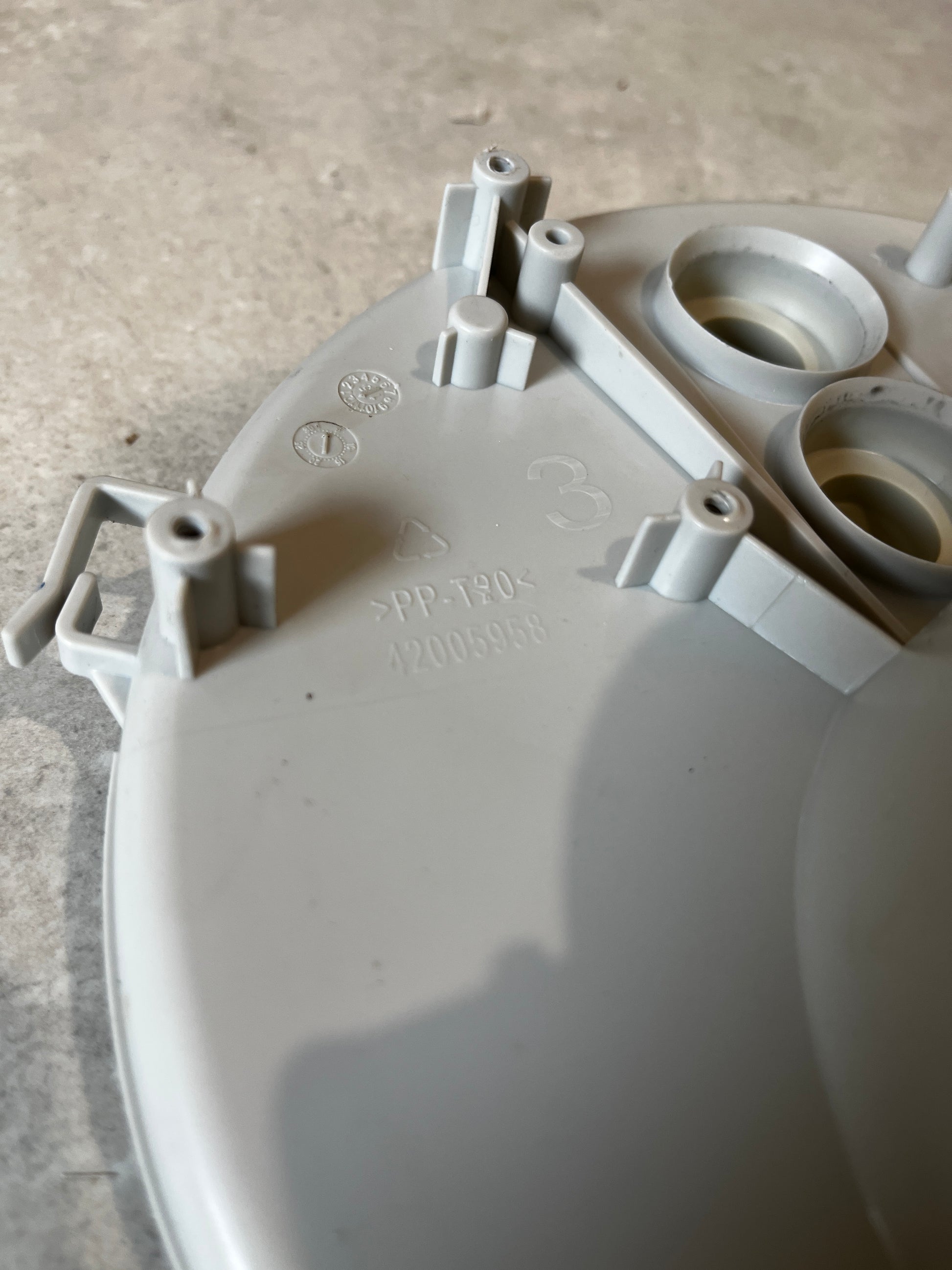 Close-up of mounting points, markings, and material info on the pump filter housing