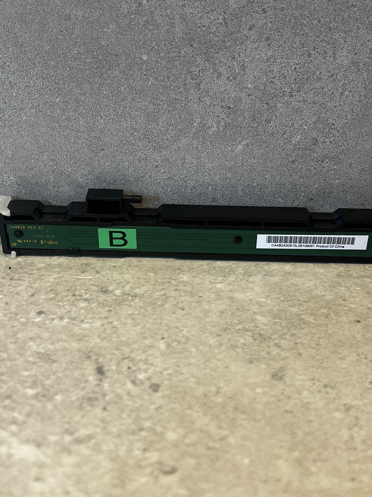 Close-up of thermal printhead circuit board with green 'B' label and barcode