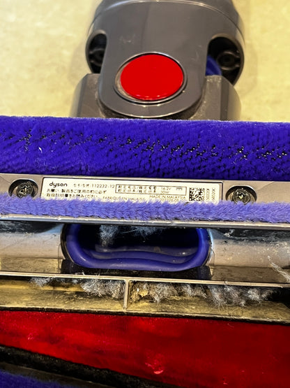 Close-up of Dyson vacuum brush head label and fabric roller with dust