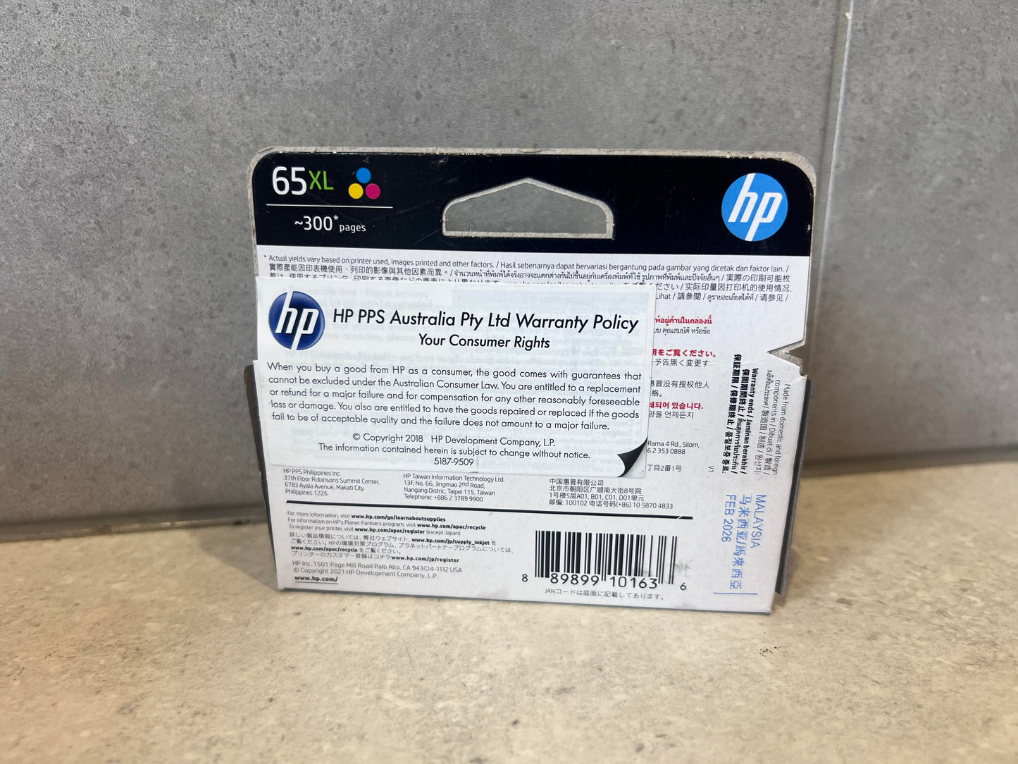 Back of HP 65XL Tri-Color Ink Cartridge packaging showing warranty and compatibility