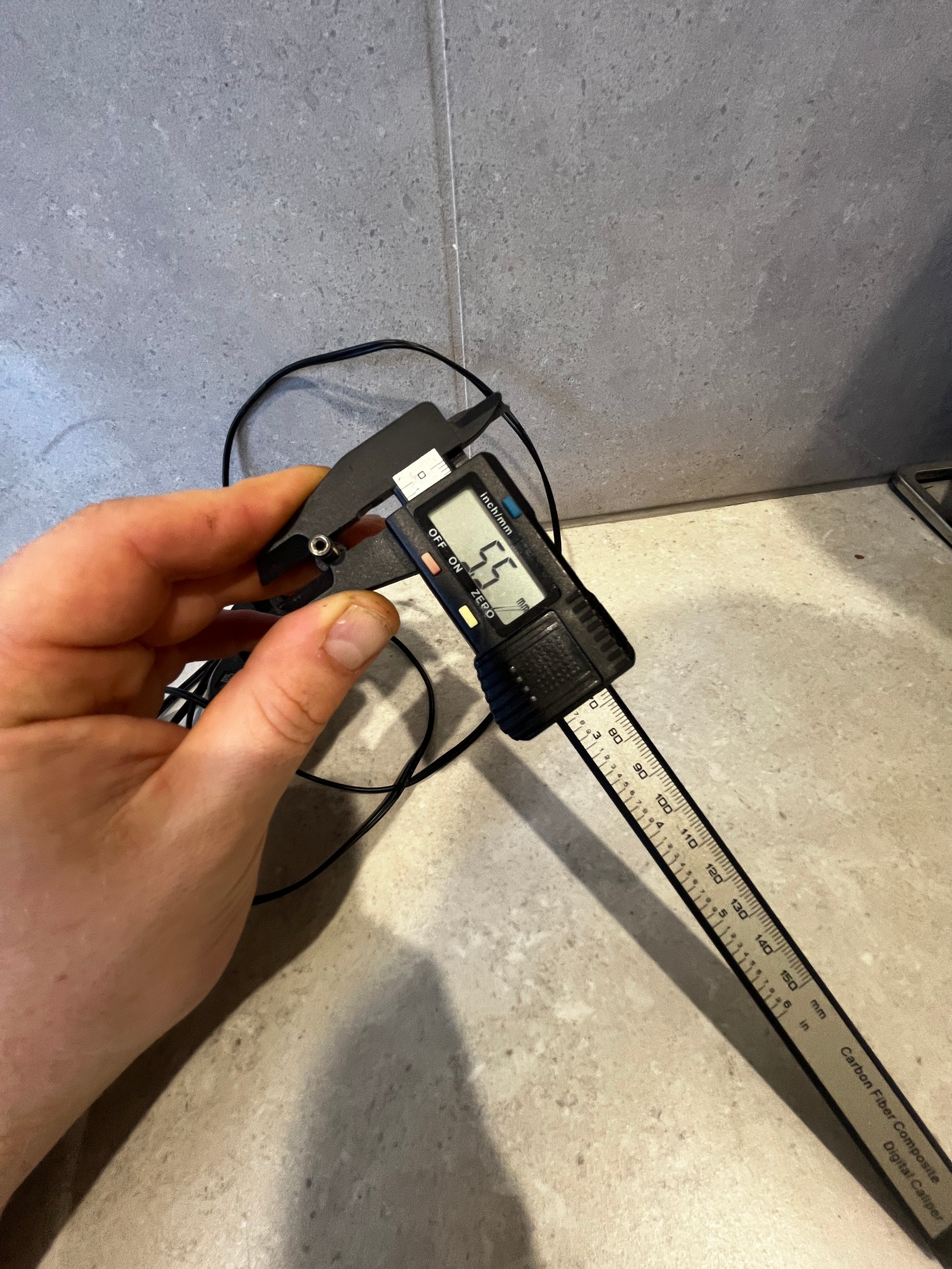 Black 16V 200mA power adapter with long cable on countertop