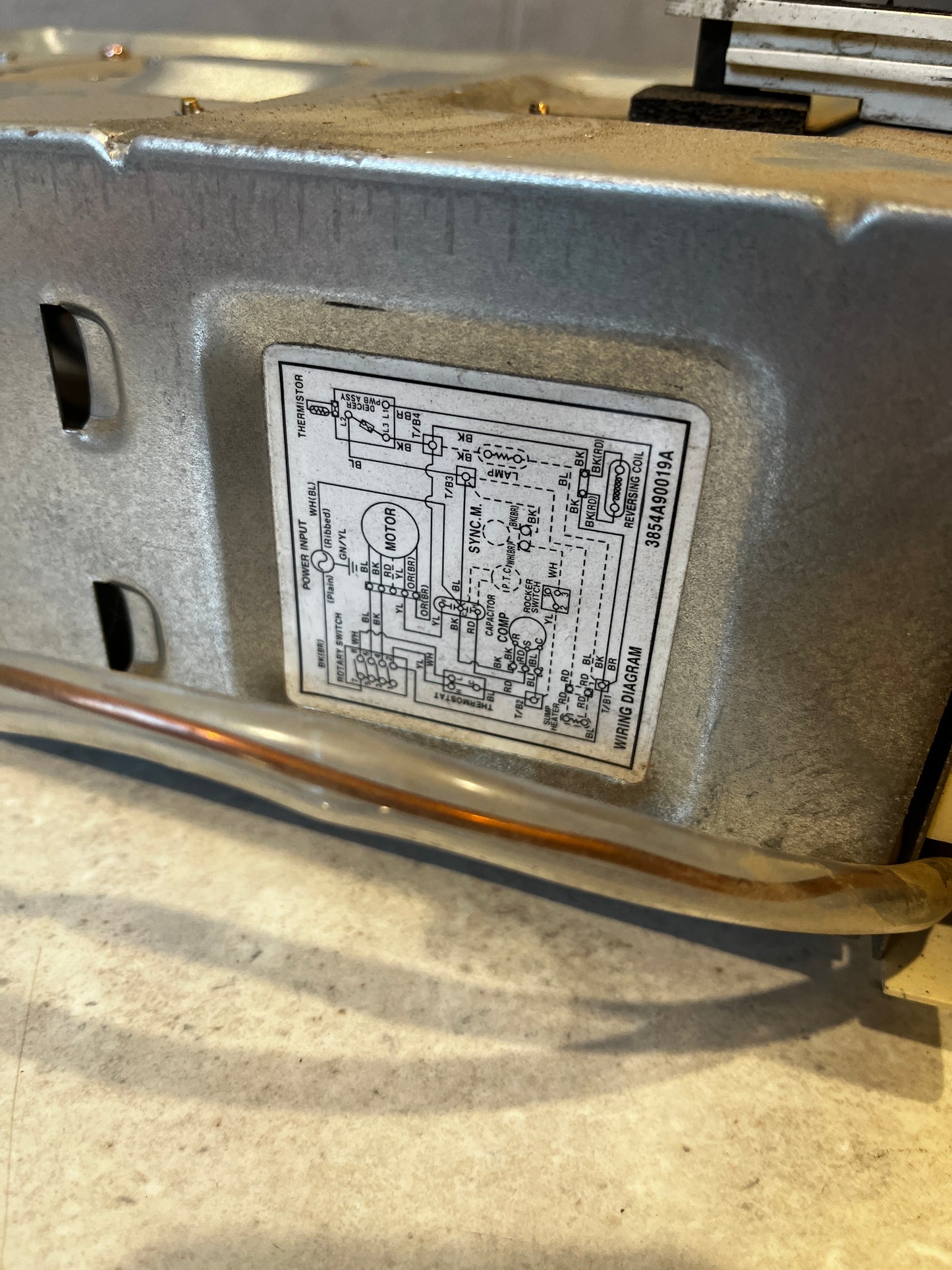 Wiring diagram label attached to metal base of thermostat control panel assembly