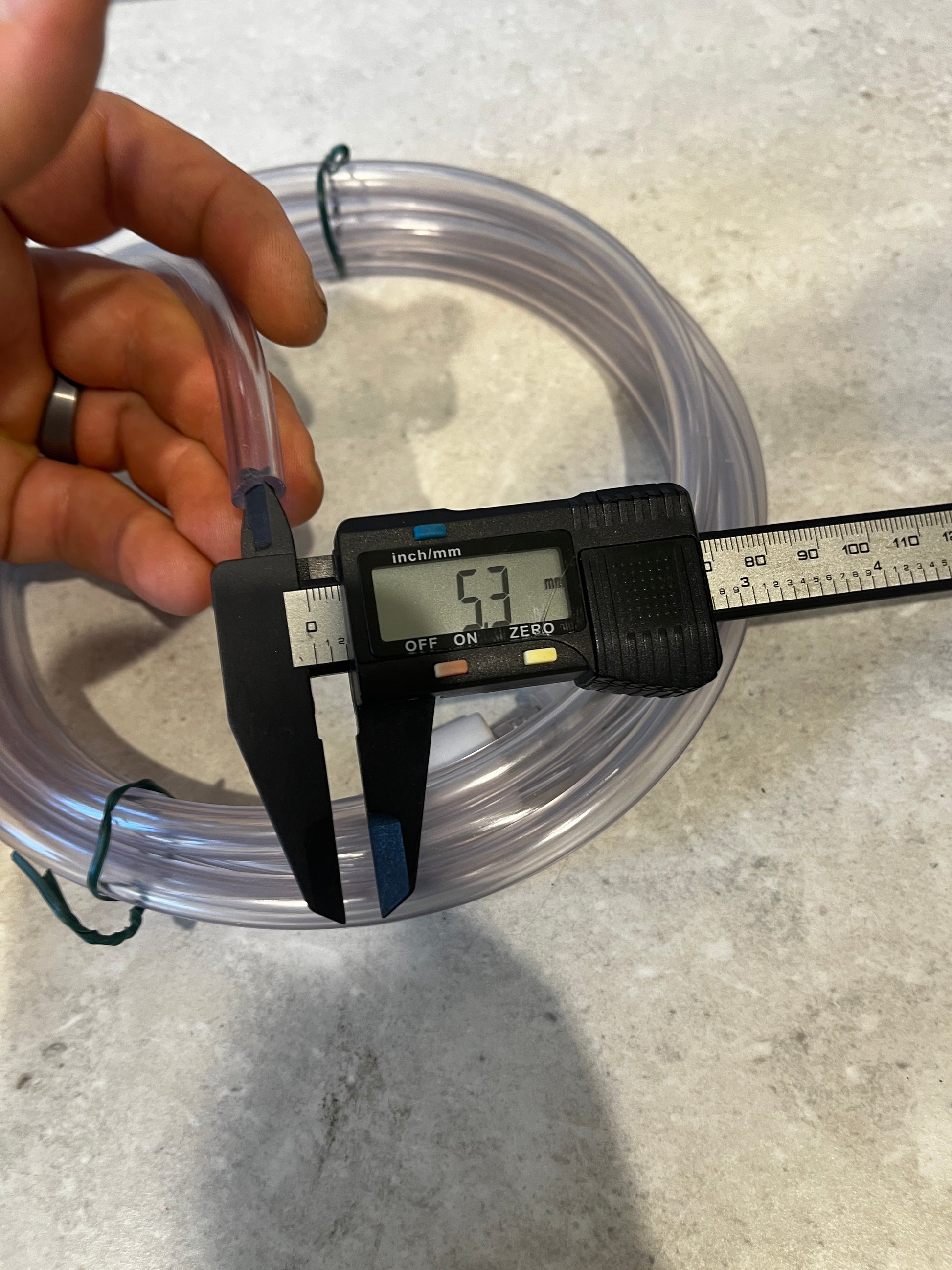 Measuring inner diameter of clear PVC tubing showing 5.3 millimeters on digital caliper