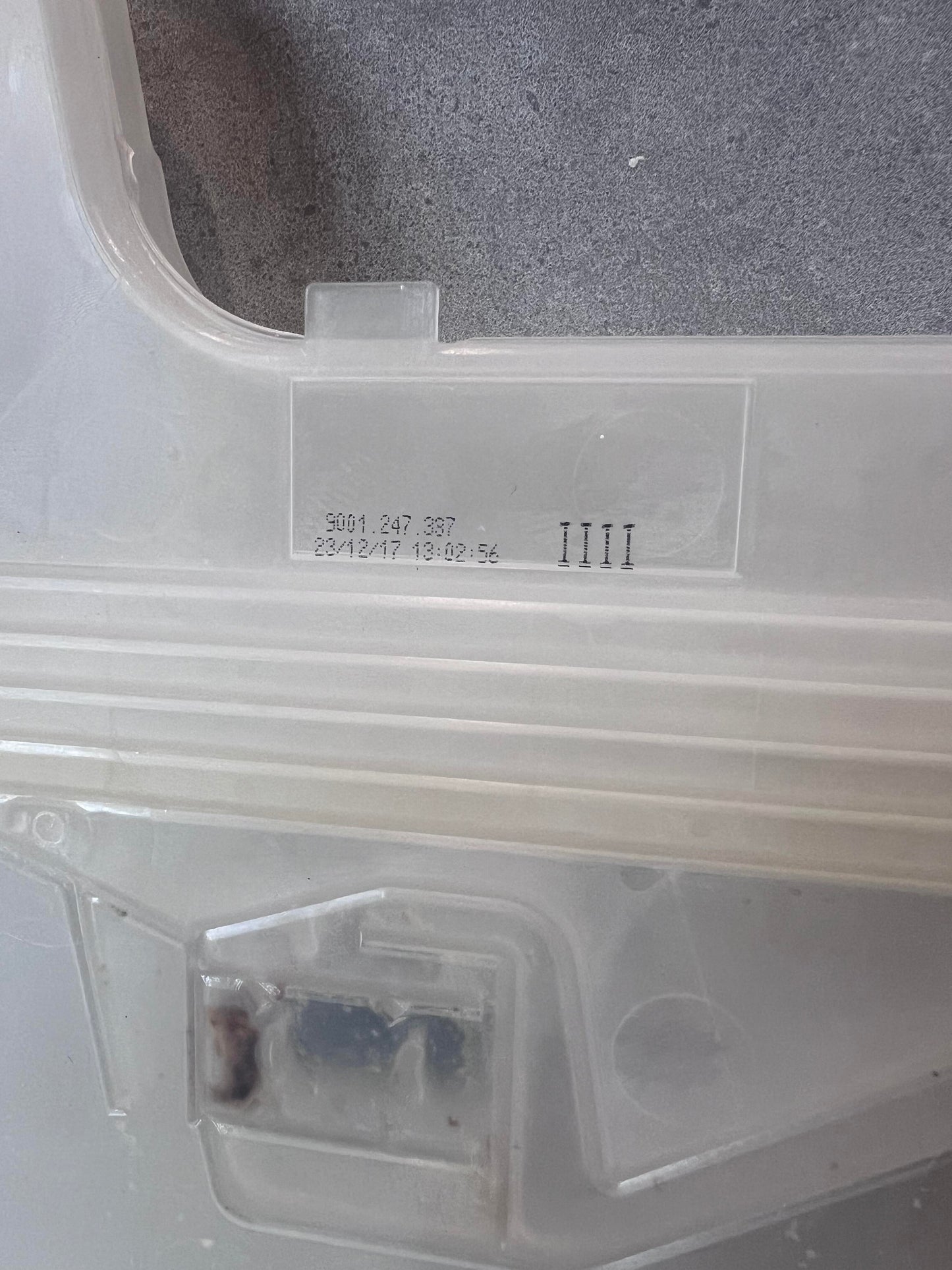 Close-up of stamped serial number on dishwasher inlet valve plastic housing