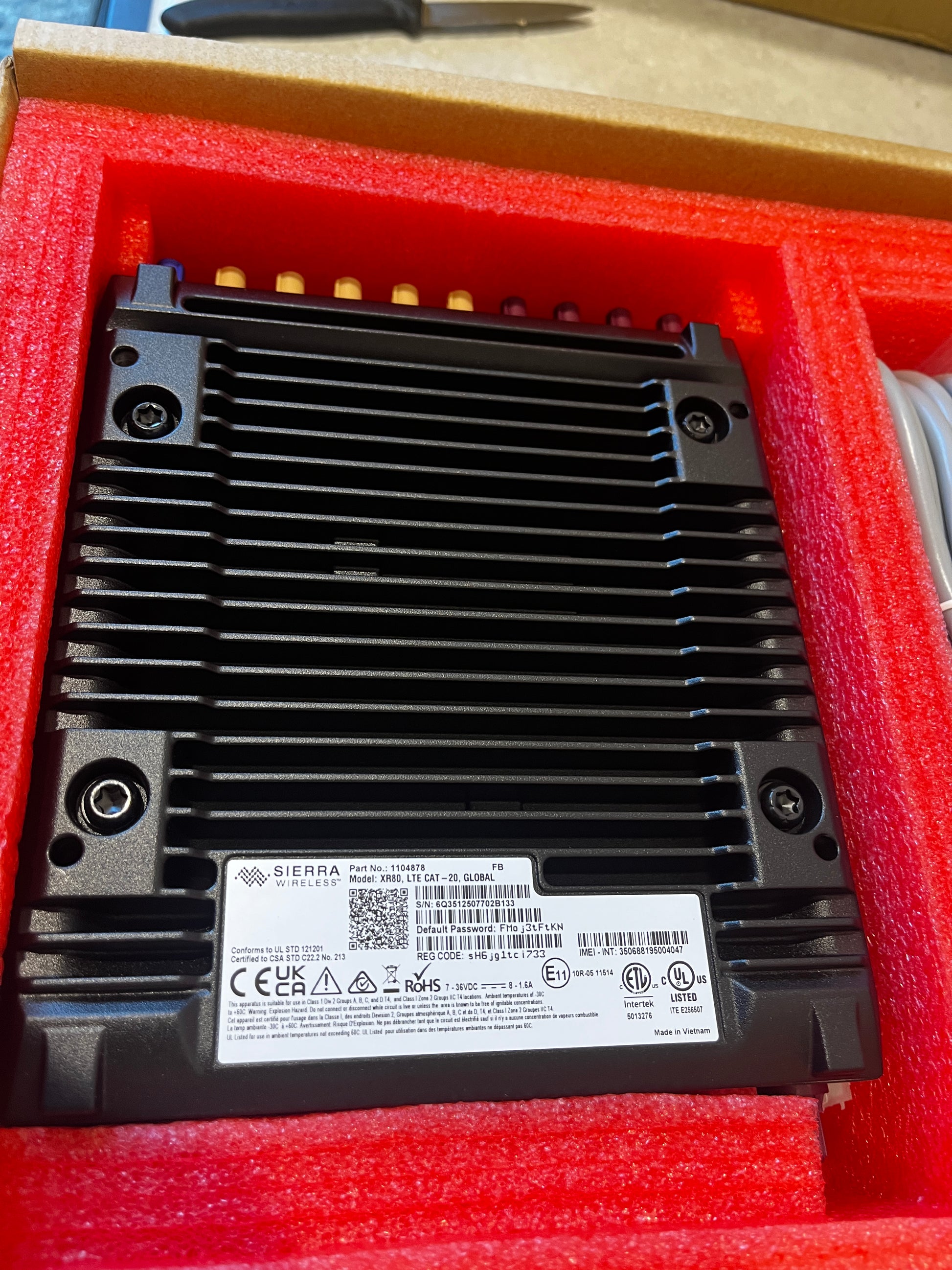 Top view of AirLink XR80 router inside protective foam with cables and accessories
