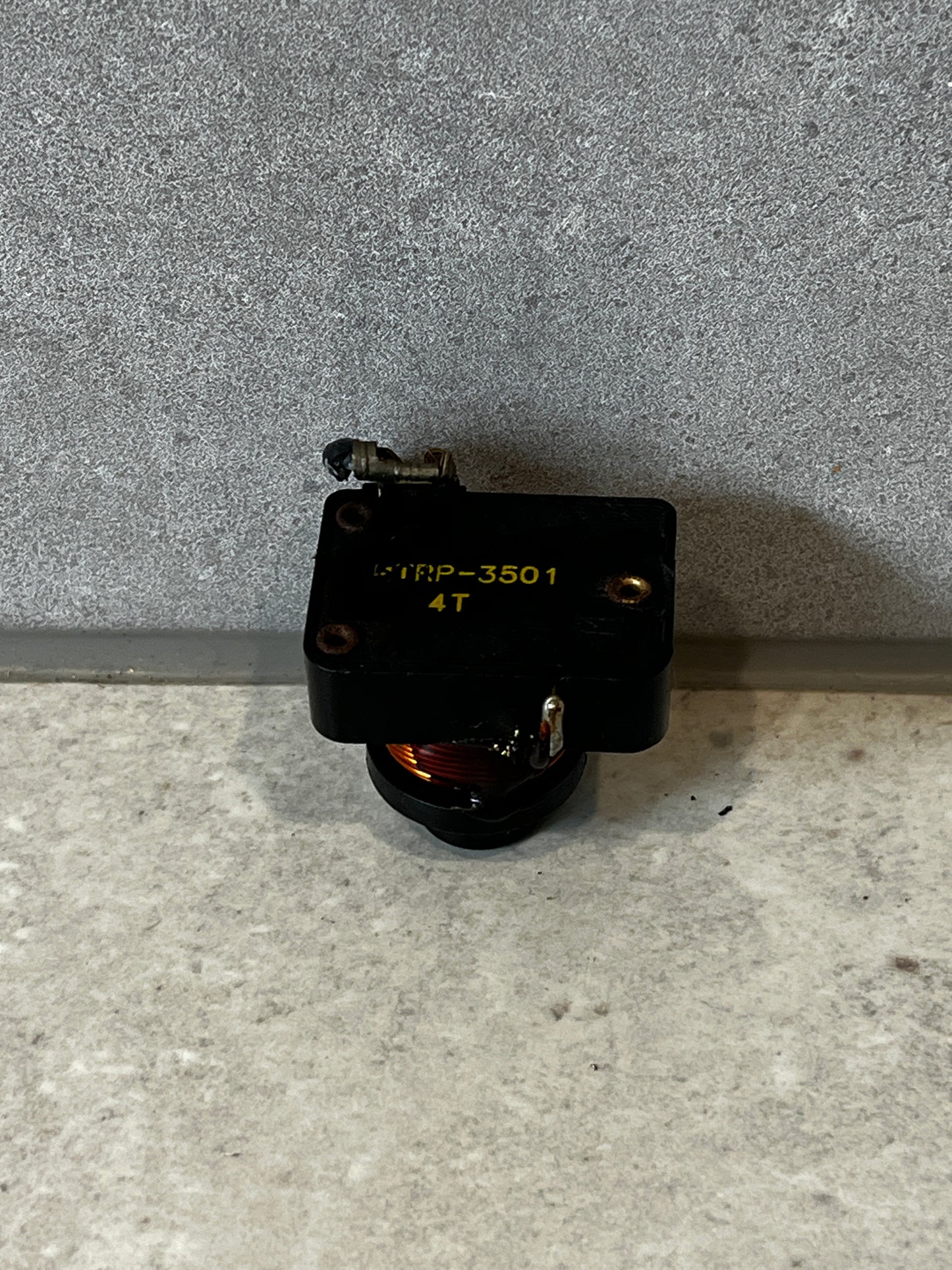 Top view of electrical relay switch with labeling and exposed copper coil