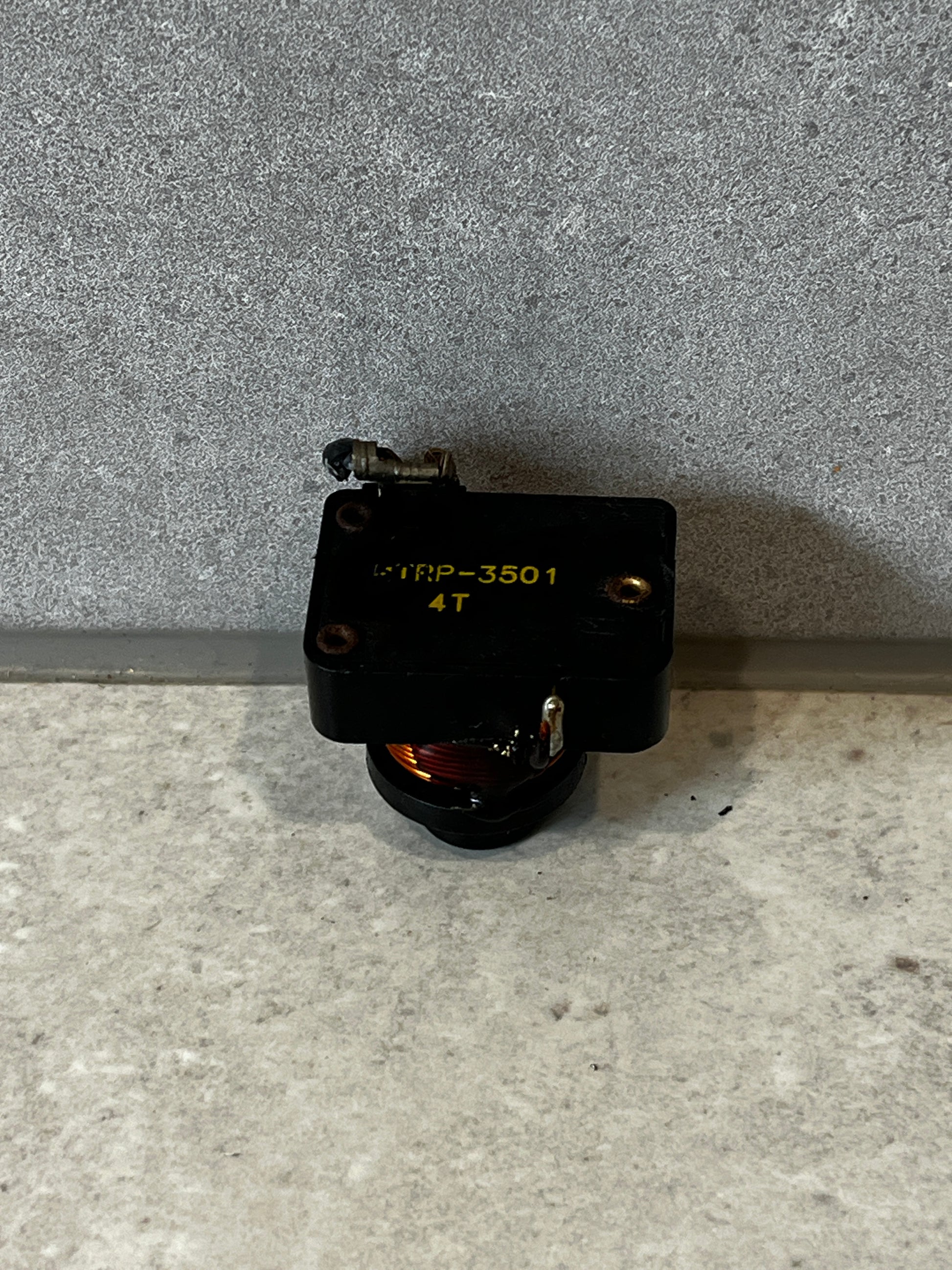 Top view of electrical relay switch with labeling and exposed copper coil