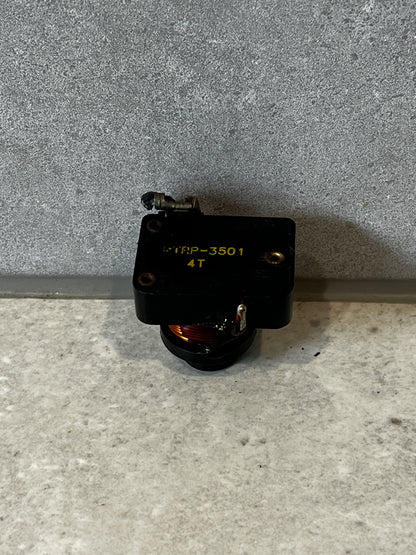 Top view of electrical relay switch with labeling and exposed copper coil