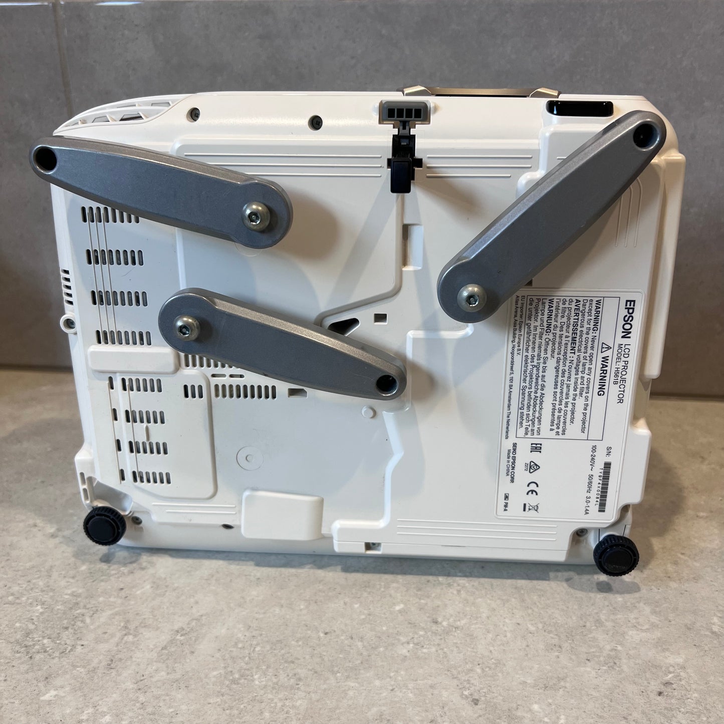 Bottom view of Epson EH-TW5200 projector showing adjustable legs and model label